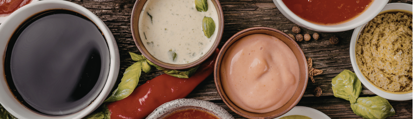selection of small pots containing different vegan dressings
