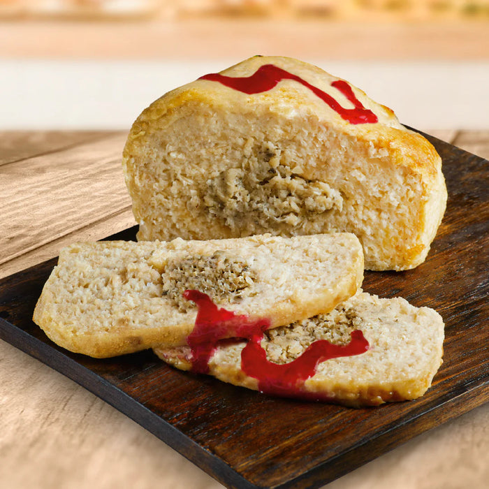Sliced vegan turkey with red sauce on a wooden board