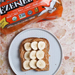 Ezekiel 4:9 sprouted wholegrain bread slice on a white plate covered in peanut butter and sliced banana