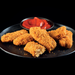 vegan breaded chicken tenders on a black plate with a saucer of tomato sauce