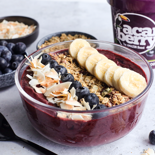 Acai bowl with toppings including bananas, blueberries, and granola, with a can of Açaí Berry in the background.
