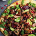 Pizza with vegan meat, vegetables, and pomegranate seeds on a wooden board