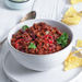Bowl of vegan chili with tortilla chips on a white surface