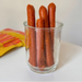 Glass jar filled with hot dog sausages on a white surface