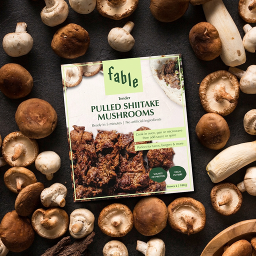 a packet of fable pulled shiitake mushrooms surrounded by raw mushrooms