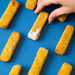 Hand holding a fish finger among others on a blue background