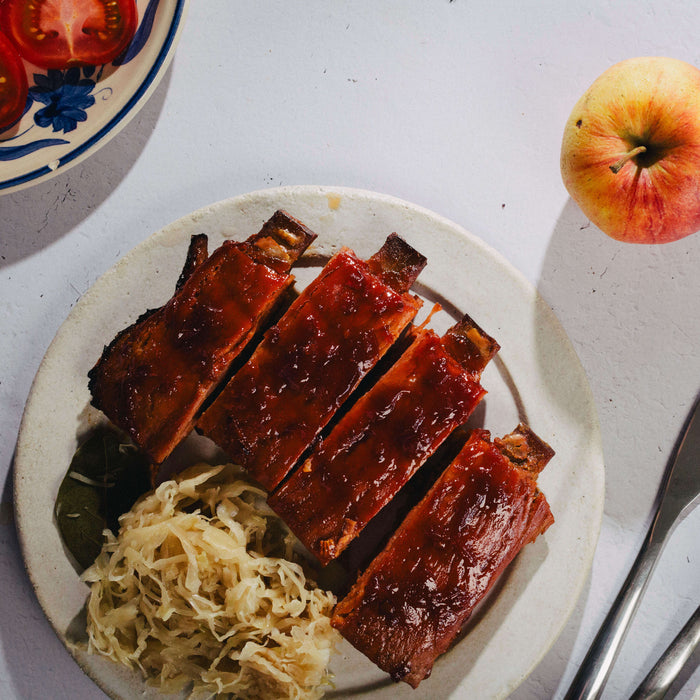 juicy marbles ribs served on placd with kimchi and an apple