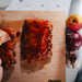 juicy marbles ribs on wooden board being glazed with apple and onion