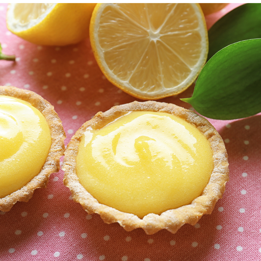 small pastry cups filled with vegan lemon curd with sliced lemons 