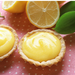 small pastry cups filled with vegan lemon curd with sliced lemons 