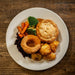 a plated roast dinner featuring a pie,vegetables and a yorkshire pudding