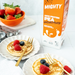 Pancakes with berries on plates next to a carton of Mighty High Protein Pea Unsweetened milk.