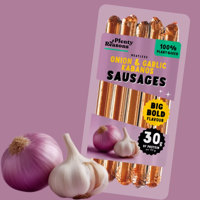 Pack of Plenty Reasons Onion & Garlic Kabanos Sausages shown on a mauve background with whole garlic bulbs and a purple onion in front of the package.