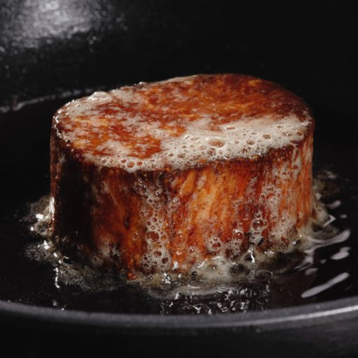 juicy marbles filet being cooked in oil in a pan