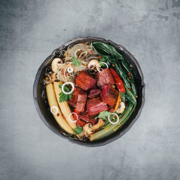 juicy marbles filet served on a a bed of salad in a bowl on marbled background