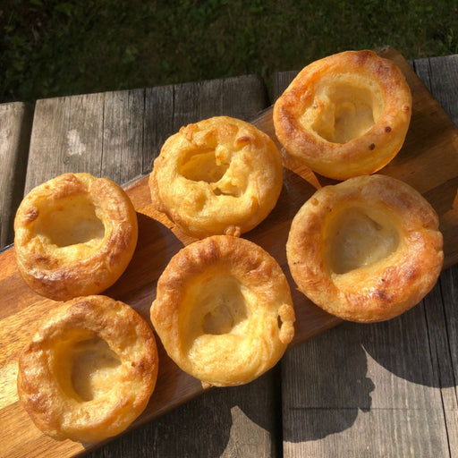 a wooden board with 6 plantside yorkshire puddings